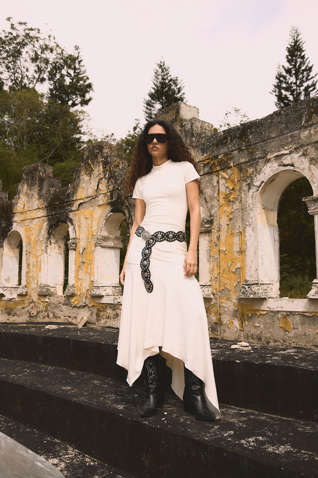 Dos modelos sentadas en el pasto: set rosa y denim con tachas